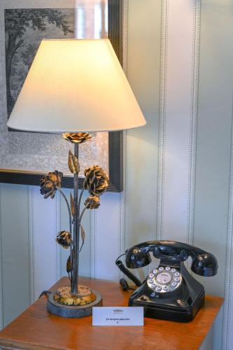 a lamp on a table next to a telephone at The Jockey Club Rooms in Newmarket