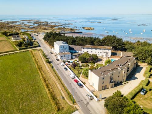 an aerial view of a road with buildings and the ocean at Hôtel de la Pointe de Mousterlin in Fouesnant