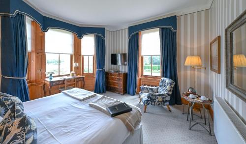 a bedroom with a bed and a desk and a chair at The Jockey Club Rooms in Newmarket