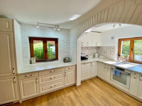 a kitchen with white cabinets and a brick wall at Villa Golda in Petrovac na Moru