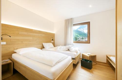 pokój hotelowy z dwoma łóżkami i oknem w obiekcie Living Nature Appartements w mieście San Vigilio di Marebbe