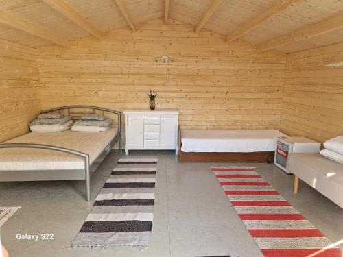 um quarto com 2 camas e uma parede de madeira em Prangli kodumajutus 