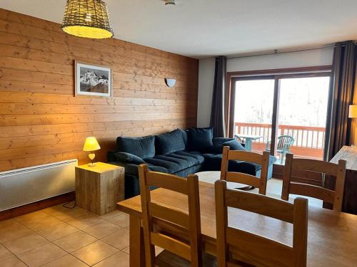 a living room with a blue couch and a table at Appartement station Sainte Foy Tarentaise in Sainte-Foy-Tarentaise