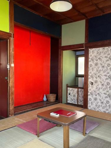 a room with a table and a red wall at Villa Sacra in Kamakura