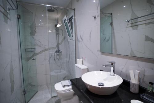 a bathroom with a sink and a shower and a toilet at Kostas Beach Apartments in Agios Gordios