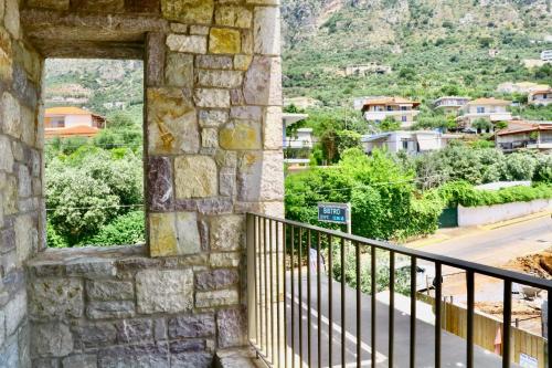 a window in a stone building with a view of a city at Petrichor in Kalamata