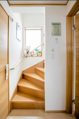 a staircase in a house with wooden floors and a window at Private lodging in WEST TOKYO(SHINJUKU, TACHIKAWA, SANRIO, GHIBLI, MT. TAKAO etc) in Kokubunji
