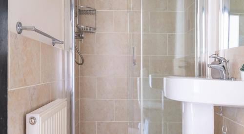 a bathroom with a shower with a sink and a sink at Hilltop in Far Sawrey