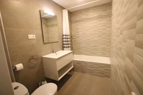 a bathroom with a toilet and a sink and a tub at Planta baja, primera linea, playa, jardín privado, Ardiaca, Cambrils, apartamento Jacqueline in Cambrils