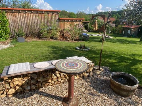 a garden with a stone bench and a fire pit at Tiny House 47 in Egloffstein