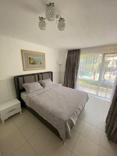 a bedroom with a large bed and a window at Апартаменты 1+1 с выходом на бассейн in Kemer