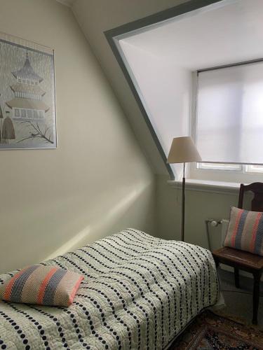 a bedroom with a bed and a window and a lamp at Bellinge House in Horreby