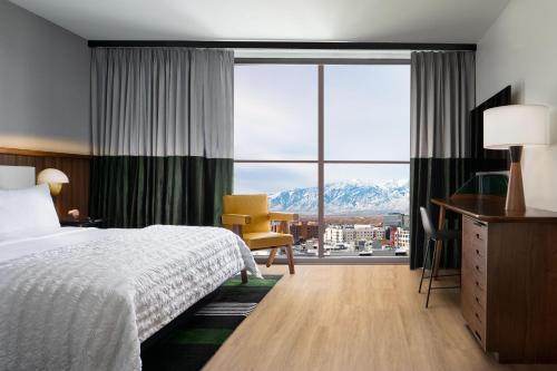 um quarto de hotel com uma cama e uma grande janela em Le Méridien Salt Lake City Downtown em Salt Lake City