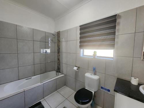 La salle de bains est pourvue de toilettes, d'une baignoire et d'un lavabo. dans l'établissement 3714 @Ribbok, à Marloth Park