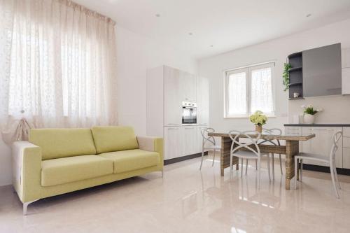 sala de estar con sofá amarillo y mesa en Dimora Via del Mare, en Carovigno