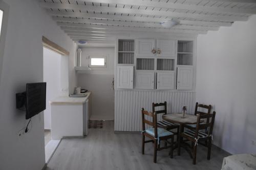 a kitchen with a table and chairs in a room at Andriani's Guest House in Mýkonos City