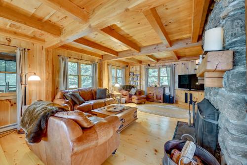 a living room with a couch and a fireplace at Lakefront Westhampton Cabin with Beach and Kayaks! in Westhampton