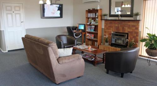 
a living room filled with furniture and a tv at City Motor Inn in Toowoomba
