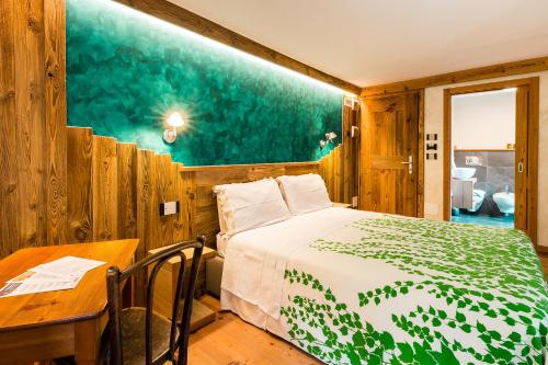 a bedroom with a bed and a desk and a table at Le Moulin Des Aravis in Pontboset