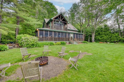 a house with chairs and a fire pit in the yard at Lakefront Westhampton Cabin with Beach and Kayaks! in Westhampton