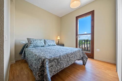 a bedroom with a bed and a large window at Casa Manolo in Torredembarra