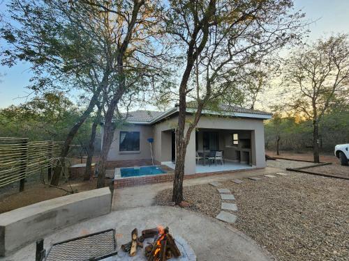 a house with a fire pit in front of it at 3714 @Ribbok in Marloth Park
