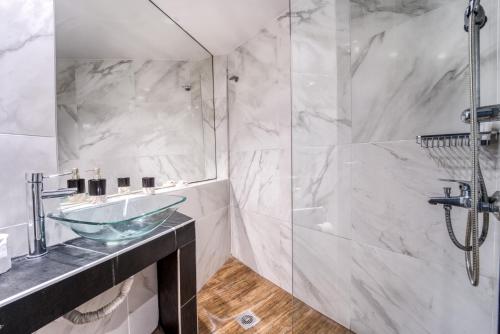 ein Bad mit einem Waschbecken und einer Dusche in der Unterkunft Island City Boutique Hotel in Rhodos (Stadt)
