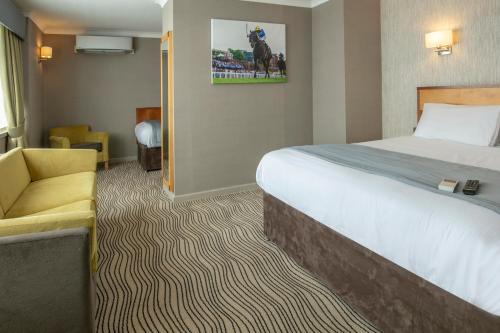 a hotel room with a bed and a chair at Best Western Heath Court Hotel in Newmarket