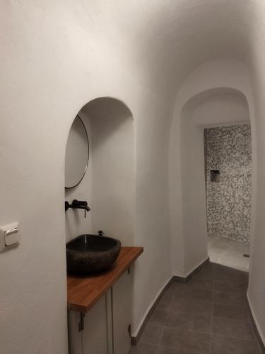 a bathroom with a sink and a mirror on a counter at AngelEve Villa with private Jacuzzi in Fira