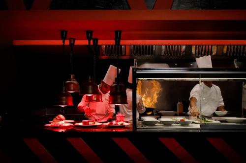 a chef in a restaurant kitchen preparing food at Riu Atoll-All Inclusive in Dhaalu Atoll