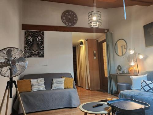 un salon avec un canapé et une horloge au mur dans l'établissement Coeur d'Albertville - Hyper Centre (Gare à 800 mètres), à Albertville