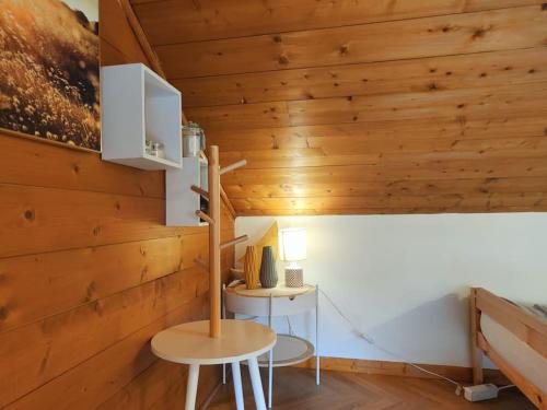 Cette chambre est dotée d'un mur en bois avec une table et une chaise. dans l'établissement Coeur d'Albertville - Hyper Centre (Gare à 800 mètres), à Albertville