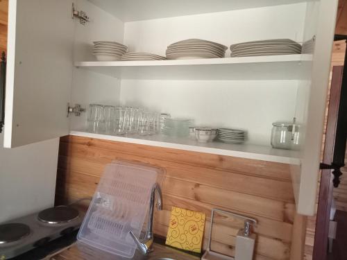 a kitchen with a shelf with plates and dishes at Yildiz Ahşap Evleri in Datca