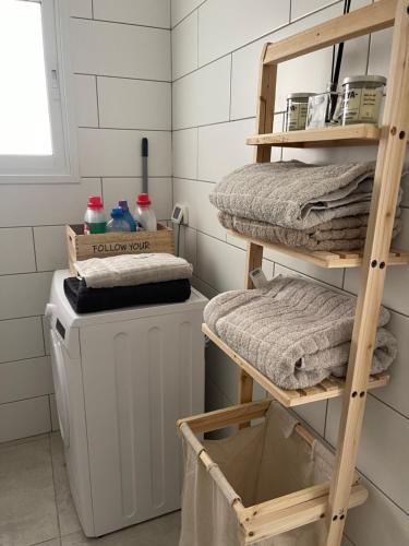 a laundry room with a washing machine and wooden shelves at Good vibes house in Rechovot