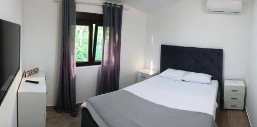 een slaapkamer met een wit bed en een raam bij MIA CASA Apartmens in Budva