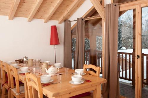 une table à manger en bois avec des chaises et une lampe rouge dans l'établissement Chalet Fegguese - 4 bedroom chalet with hot-tub, à Sainte-Foy-Tarentaise