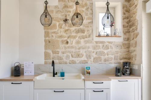 een keuken met een wastafel en een stenen muur bij Paisible escale pres de la plage in Plobannalec-Lesconil
