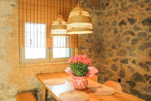 a table with a vase of flowers and two lights at Petrichor in Kalamata
