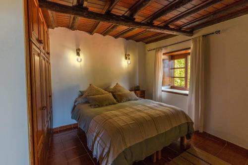 a bedroom with a bed in a room with a window at LAS CASITAS DEL BEBEDERO - Yoga & Ecoturismo in Icod de los Vinos
