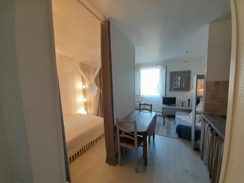 a bedroom with a bed and a desk and a mirror at Romance à 70 m de la plage in Royan