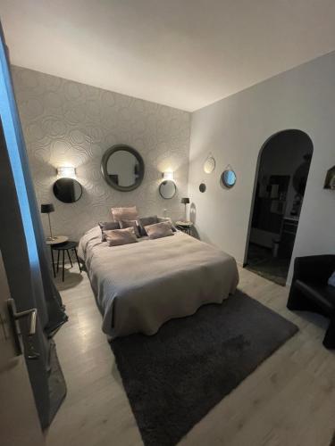 a bedroom with a large bed and a mirror at BARREAU in Libourne