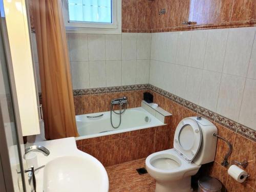 a bathroom with a toilet and a sink and a tub at Klarida house in Kirás Vrísi