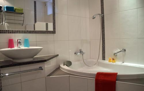 a white bathroom with a sink and a tub at Appartement Schilcher in Oberau