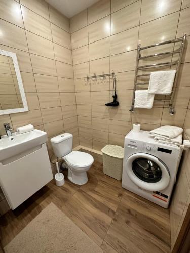 a bathroom with a washing machine and a toilet at Apartment, Podillya in Vinnytsya