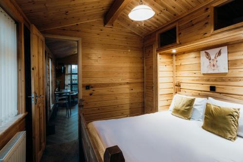 a bedroom with a bed in a wooden room at Woodlakes Park By Liv Retreats in Kings Lynn