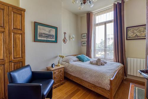 une chambre avec un lit, une chaise et une fenêtre dans l'établissement Le Jules Verne - Idéalement situé avec sauna, à Calais