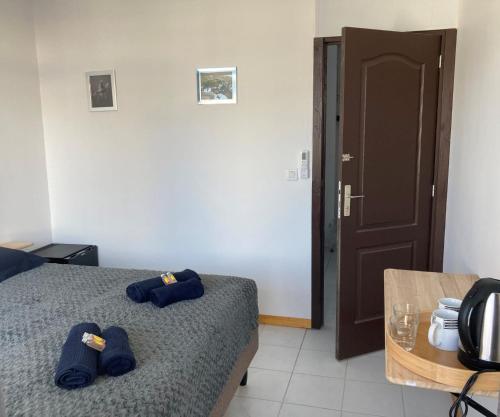 ein Schlafzimmer mit einem Bett mit blauen Hausschuhen darauf in der Unterkunft "Frangipani" city center room in Papeete