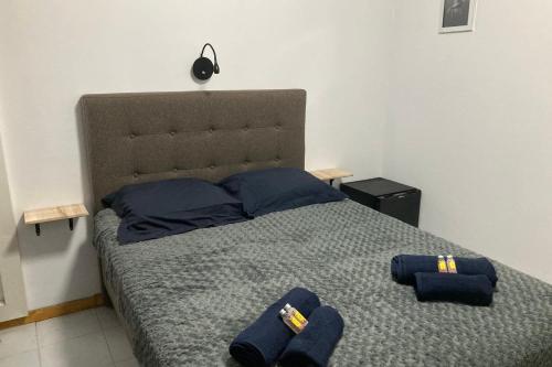 una camera da letto con un letto con asciugamani blu di "Frangipani" city center room a Papeete