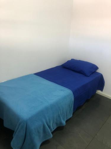 a bedroom with two beds with blue sheets at Pousada 714 in Brasília