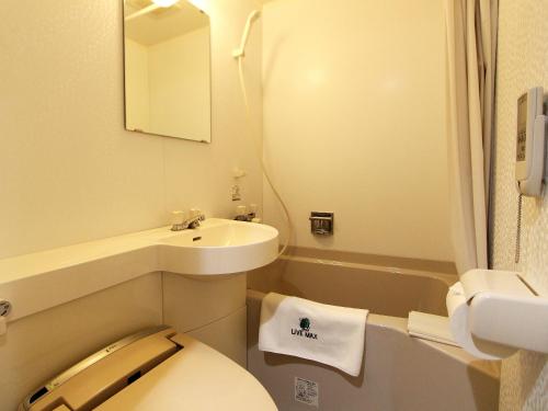 a small bathroom with a toilet and a sink at HOTEL LiVEMAX BUDGET Fuchu Annex in Fuchu